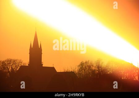 Sonnenuntergang über der Silhouette der Kirche, aufgenommen mit einer speziellen Langzeitbelichtung. Stockfoto