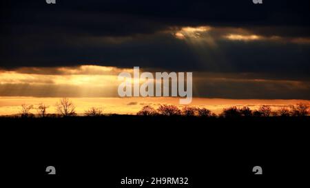 Sonnenstrahlen durchbrechen die Wolkendecke in einer Gegenlichtaufnahme. Stockfoto