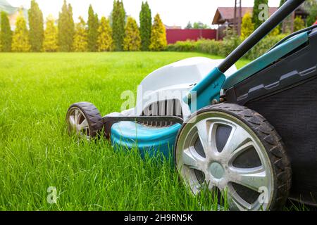 Rasenmäher aus der Nähe an einem sonnigen Tag. Rasenpflege. Gartenkonzept. Stockfoto