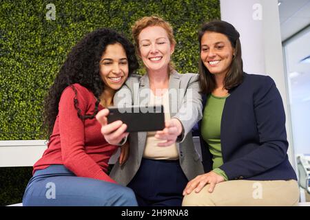 Drei junge Frauen als Freunde mit Smartphones machen ein Selfie für Social Media Stockfoto