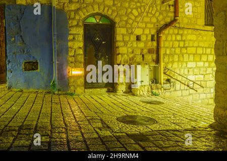 Safed, Israel - 05. Dezember 2021: Ansicht einer Gasse im jüdischen Viertel mit einer traditionellen Menora (Hanukkah-Lampe) mit Olivenölkerzen, platziert ne Stockfoto