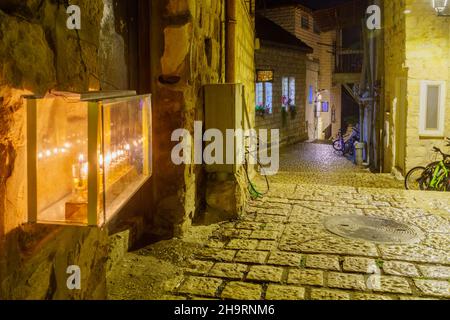 Safed, Israel - 05. Dezember 2021: Ansicht einer Gasse im jüdischen Viertel mit einer traditionellen Menora (Hanukkah-Lampe) mit Olivenölkerzen, platziert ne Stockfoto