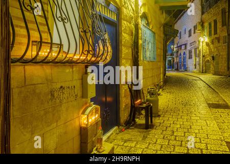 Safed, Israel - 05. Dezember 2021: Ansicht einer Gasse im jüdischen Viertel mit einer traditionellen Menora (Hanukkah-Lampe) mit Olivenölkerzen, platziert ne Stockfoto