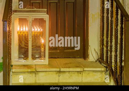 Safed, Israel - 05. Dezember 2021: Blick auf eine traditionelle Menora (Hanukkah-Lampe) mit Ölkerzen, aufgestellt nahe dem Eingang, in Safed (Tzfat), I Stockfoto