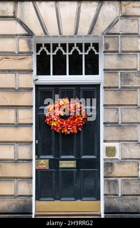 Georgianisches Stadthaus, schwarz bemalte Eingangstür mit saisonalem Kranz, Edinburgh New Town, Schottland, Großbritannien Stockfoto