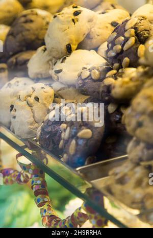 Viele weiße und schokoladenrunde Kekse mit Nüssen darauf. Konditorei mit frischen Keksen. Traditionelle italienische venezianische Süßigkeiten. Kohlenhydratfutter Stockfoto