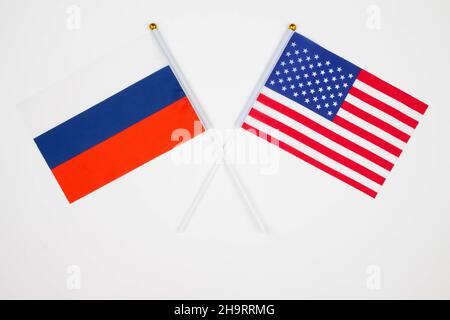 Russland-Flagge und USA-Flagge kreuzten sich auf weißem Hintergrund. Russland vs. USA. Treffen zwischen den Präsidenten Russlands und United Stockfoto