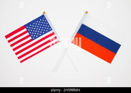 Die Flagge der USA und Russlands kreuzten sich auf weißem Hintergrund. USA vs. Russland. Treffen zwischen den Präsidenten der Vereinigten Staaten und Russi Stockfoto