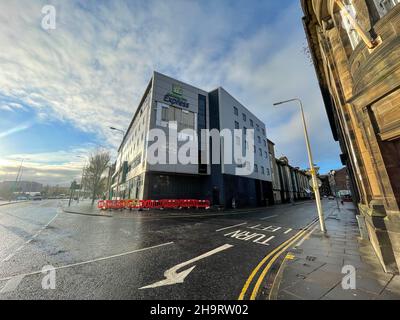 Holiday Inn Express, Dundee, Tayside, Schottland, 8th. Dezember 2021: Im Bild: Sturm Barra hat die Verkleidung von der Seite des Holiday Inn Express gerissen, was dazu führte, dass die angrenzende Straße für einige Zeit gesperrt wurde, bis eine strukturelle Bewertung im Ausmaß des Schadens durchgeführt wurde. Auf dem darunter liegenden Bürgersteig wurden provisorische Barrieren errichtet. Kredit:Barry Nixon/Alamy Live Nachrichten Stockfoto