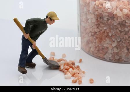 Modellarbeiter schaufelt rosa und weißes Steinsalz. Stockfoto