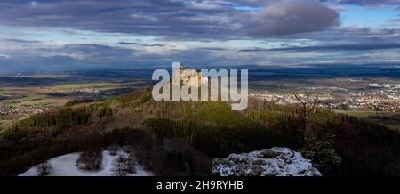 Blick vom Zellerhorn auf die Burg Hohenzollern mit Lichtspielen und einem kontrastreichen, tiefblauen Himmel im Winter Stockfoto