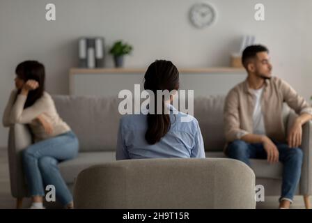 Rückansicht einer Psychologin, die dem streitsüchtig-arabischen Paar im Büro eine Therapiesitzung gab und ihnen bei Konflikten half Stockfoto
