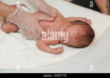 Physiotherapeut, der mit einem Neugeborenen in einem medizinischen Zentrum arbeitet. Stockfoto