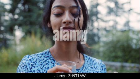 Eine ehrliche Aufnahme einer südasiatischen Frau, die ein Glas Wein zum Anstoßen in der Hand hält Stockfoto