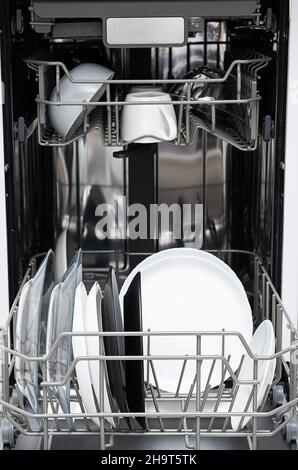 Reinigen Sie die Teller nach dem Waschen in der Spülmaschine zu Hause. Moderne Küche mit Geschirrspüler. Haushaltsgeräte. Stockfoto