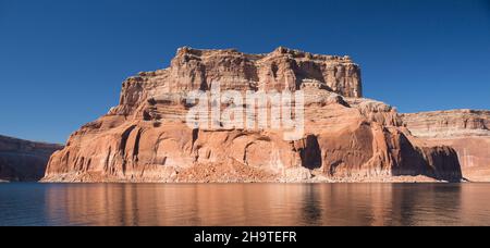 Glen Canyon National Recreation Area, Utah, USA. Majestätische rote sandsteinbutte spiegelt sich in den ruhigen Gewässern des Lake Powell wider. Stockfoto