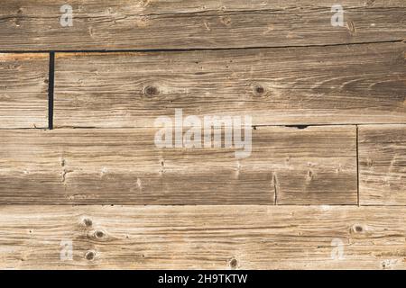 Holzhintergrund aus braunen Holzbrettern unter der Sonne. Abstraktes Muster im rustikalen Stil, Kopierraum Stockfoto