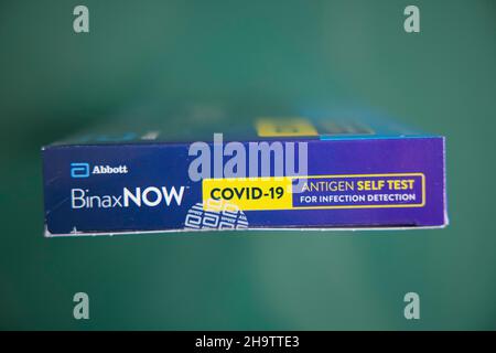 Nahaufnahme eines schnellen Covid-19-Tests von Abbott zu Hause in einer blauen Box mit zwei Personen auf grünem Hintergrund, New York City, NY 10031, USA, 8. Januar 2021. Stockfoto