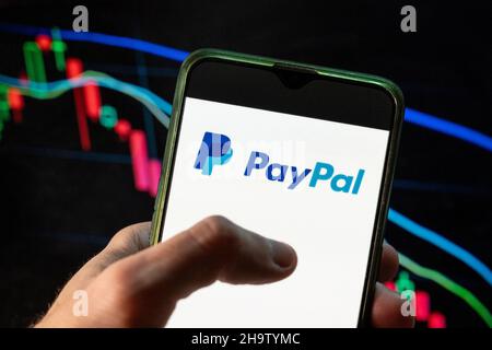 China. 09th Dez 2021. In dieser Fotolabbildung die amerikanische Online-Zahlungsplattform, Paypal-Logo auf einem Smartphone mit einem wirtschaftlichen Börsenindex-Diagramm im Hintergrund zu sehen. Kredit: SOPA Images Limited/Alamy Live Nachrichten Stockfoto