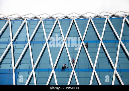 Astana /Kasachstan - 04/28/2017: Die Ansicht des Gebäudes auf dem Unabhängigkeitsplatz. Arbeiter putzen die Fassade eines Gebäudes. Stockfoto