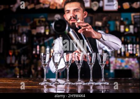 Bartender beendet seine Kreation intensiv an der Bar Stockfoto