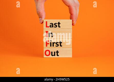 LIFO Last in First Out Symbol. Konzept Wörter LIFO dauern zuerst heraus auf hölzernen Blöcken. Schöne orange Tisch orange Hintergrund. Geschäftsmann Hand. Busi Stockfoto
