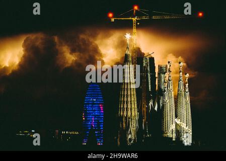 Barcelona, Spanien. 9th Dez 2021. Hinter der Sagrada Familia und ihrem neuen riesigen Kristallstern, der die Spitze der Basilika krönt und zum ersten Mal beleuchtet wird, um die Fertigstellung des zu feiern, zieht sich ein Gewitter um Mitternacht ein. Aufgrund der Corona-Virus-Krise wurde der Fertigstellungstermin verschoben, und es wird kein neuer Termin bis 2024 bekannt gegeben, wenn die Arbeiten hoffentlich wieder im Tempo von 2019 durchgeführt werden. Quelle: Matthias Oesterle/Alamy Live News Stockfoto