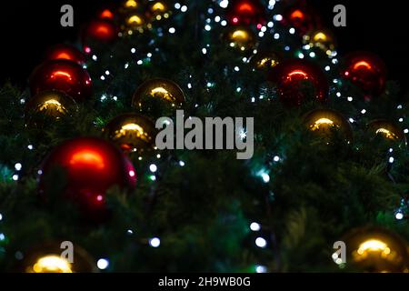 Große rote und goldene Weihnachtsbaumschmuck auf einer Kiefer Stockfoto