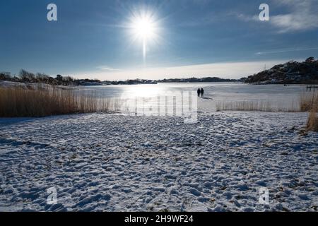 Zwei Personen gehen im Winter auf Eis Stockfoto