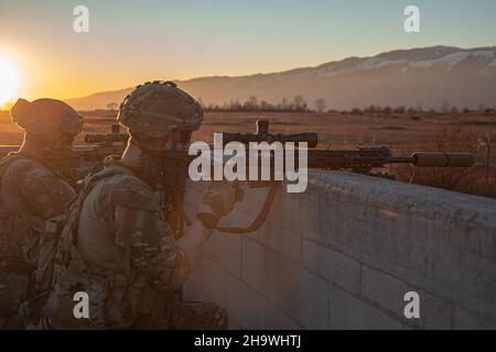 Aufklärungspatrooper der US-Armee, die 1st Bataillons zugewiesen wurden, 503rd Fallschirmjäger-Regiment sorgen für Sicherheit von einem Dach aus, nachdem sie während einer Validierungsübung für die Nord- und westafrikanische Einsatztruppe am 7. Dezember 2021 im Dandolo Range in Pordenone, Italien, einen Angriff auf ein Dorf durchgeführt haben. Die Nord- und westafrikanische Reaktionstruppe ist eine Direktive der Southern European Task Force - Africa der US Army, die 173rd Infanterieeinheiten der Airborne Brigade als entscheidendes, nach vorne geposturtes, schnelles Reaktionselement für krisenbedingte Aufgaben im United States Africa Command einsetzt Stockfoto