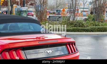 Red Muscle Car Ford Mustang auf der Straße geparkt. Nahaufnahme der Rückseite eines Ford Mustang Autos in Langley BC, Kanada-November 23,2021. Blick auf die Straße, sel Stockfoto