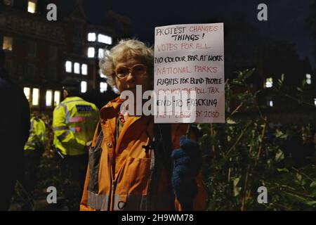 London, Großbritannien, 8th. Dezember 2021, eine Frau mit einem Plakat, auf dem positive Ergebnisse des Protests dargelegt werden. Sie war eine von Hunderten, die in Westminster zu einem „Kill the Bill“ zusammengekommen waren, als die dritte Lesung des Gesetzes über Polizei, Verbrechen, Verurteilung und Gerichte (PCSC) im Oberhaus begann. Das neue Gesetz wird der Polizei, sofern es angenommen wird, zusätzliche Befugnisse zur Einschlagung von Protesten geben, indem es Stopp-und-Durchsuchung, den Datenaustausch von Aktivisten-Details und die Auflösung von Demonstrationen, die als „ernsten Ärger“ angesehen werden, ermöglicht. Kredit: Elfte Stunde Fotografie/Alamy Live Nachrichten Stockfoto