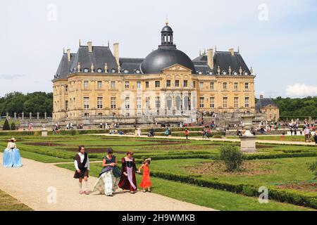 Kostümierte Besucher durchstreifen das Gelände des Chateau Vaux le Vicomte während des jährlichen Grand Siècle Day, der die historische Barockzeit feiert. Stockfoto