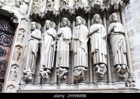 Historische Statuen der Heiligen Paul, James, Thomas, Philip, Jude und Matthew flankieren den Eingang an der façade der Kathedrale Notre Dame in Paris, Frankreich. Stockfoto