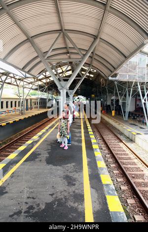 Menschen, die auf dem Bahnsteig darauf warten, dass ihr Zug am Bahnhof Yogyakarta in Zentral-Java, Indonesien ankommt. Stockfoto