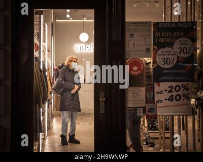 Bild von weißen kaukasischen Menschen in belgrad, serbien, in einem Bekleidungsgeschäft, das in Belgrad, der Hauptstadt Serbiens, auf einen Kauf wartet, während sie müde sind Stockfoto