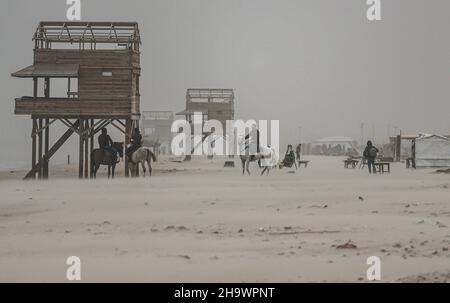 Gaza, Palästina. 08th Dez 2021. Palästinenser reiten bei stürmischem Wetter auf Pferden am Strand entlang. Kredit: SOPA Images Limited/Alamy Live Nachrichten Stockfoto