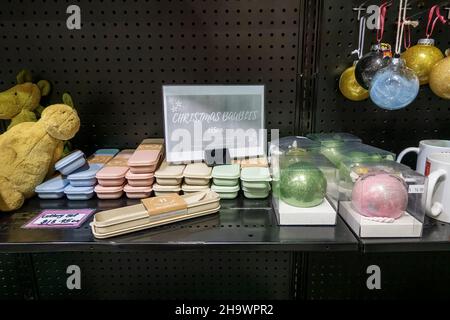 Mackay, Queensland, Australien - Dezember 2021: Weihnachtskugeln und Besteckverpackungen neben Stoffspielzeug zum Verkauf im Ladenregal Stockfoto