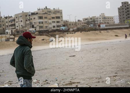 Gaza, Palästina. 08th Dez 2021. Ein Palästinenser schaut auf die Wellen, die während des stürmischen Wetters am Strand auftrafen. (Foto von Ahmed Zakot/SOPA Images/Sipa USA) Quelle: SIPA USA/Alamy Live News Stockfoto