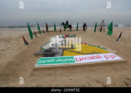 Gaza, Palästina. 07th Dez 2021. Ein Sandgraffiti mit Parolen, die von Palästinensern am Strand anlässlich des 34th. Jahrestages der Gründung der Hamas-Bewegung gemacht wurden. Kredit: SOPA Images Limited/Alamy Live Nachrichten Stockfoto