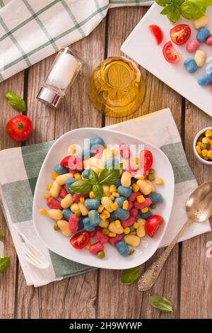 Farbige Gnocchi mit Gemüse und süßem Mais. Stockfoto