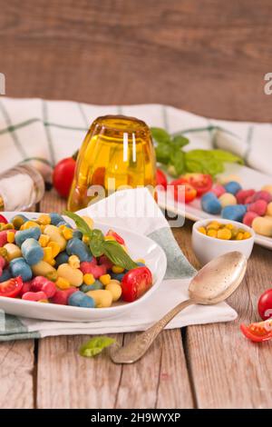 Farbige Gnocchi mit Gemüse und süßem Mais. Stockfoto