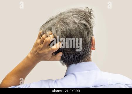 Rückansicht eines älteren Mannes, der den Kopf kratzt Stockfoto