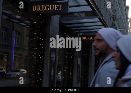 Luxusuhrgeschäft Breguet an der Bahnhofstrasse, Einkaufsstraße in Zürich, mit weihnachtlicher Dekoration. Ein junges Paar kommt am Schaufenster vorbei. Stockfoto