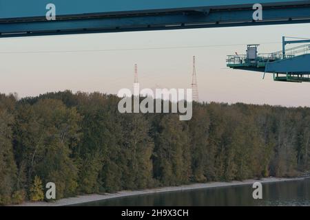 Blick auf Mount Hood über der mit Bäumen und Sträuchern bedeckten Hayden Island vom Portland Container Terminal aus. Stockfoto