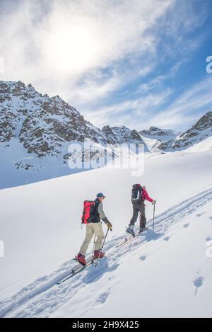 Sportliche Freunde auf Ski-Bergsteigerstrecke bergauf Stockfoto