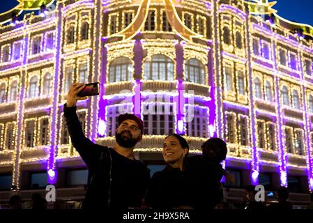 Curitiba, Brasilien. 08th Dez 2021. Ein Paar macht ein Selfie vor der Weihnachtsdekoration des Palacio Avenida. Der Palacio Avenida ist eines der schönsten Gebäude des Landes zu Weihnachten. Quelle: Henry Milleo/dpa/Alamy Live News Stockfoto