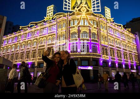 Curitiba, Brasilien. 08th Dez 2021. Touristen fotografieren vor der Weihnachtsdekoration des Palacio Avenida. Der Palacio Avenida ist eines der schönsten Gebäude des Landes zu Weihnachten. Quelle: Henry Milleo/dpa/Alamy Live News Stockfoto