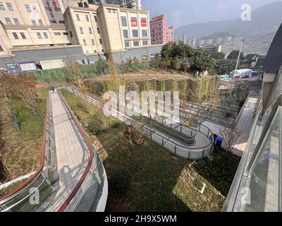 Chongqing, Chongqing, China. 9th Dez 2021. Am 24. November 2021 wurde der malerische Wanderweg am nördlichen Ende der Dongshuimen-Brücke im Bezirk Yuzhong, Stadt Chongqing, in Betrieb genommen. Dieser malerische Weg schlängelt sich den steilen Hang neben der Brücke hinunter. Er ist etwa 300 Meter lang und erfordert 19 Kurven auf und ab. Der Weg verläuft entlang des steilen Berges und bildet eine Landschaft aus Hängen und Klippen mit dem 'magischen Temperament' der Bergstadt. Sie wurde von den Netzzenen als „magisch gierige Schlange“ bezeichnet. (Bild: © SIPA Asia via ZUMA Press Wire) Stockfoto