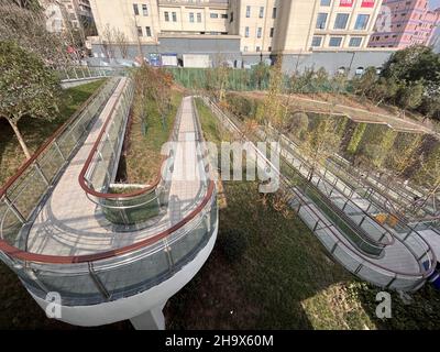 Chongqing, Chongqing, China. 9th Dez 2021. Am 24. November 2021 wurde der malerische Wanderweg am nördlichen Ende der Dongshuimen-Brücke im Bezirk Yuzhong, Stadt Chongqing, in Betrieb genommen. Dieser malerische Weg schlängelt sich den steilen Hang neben der Brücke hinunter. Er ist etwa 300 Meter lang und erfordert 19 Kurven auf und ab. Der Weg verläuft entlang des steilen Berges und bildet eine Landschaft aus Hängen und Klippen mit dem 'magischen Temperament' der Bergstadt. Sie wurde von den Netzzenen als „magisch gierige Schlange“ bezeichnet. (Bild: © SIPA Asia via ZUMA Press Wire) Stockfoto